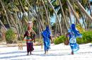 Local women walking along a beach, Zanzibar